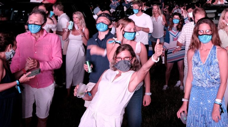 Some concertgoers stand at a VIP area during The Chainsmokers'...