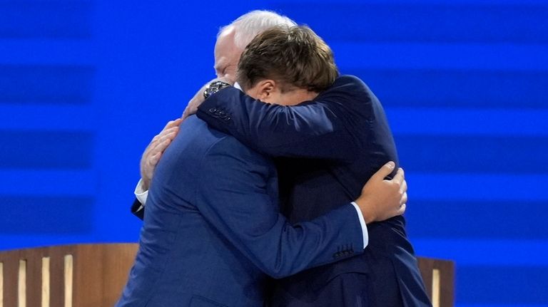 Democratic vice presidential nominee Minnesota Gov. Tim Walz, right, hugs...