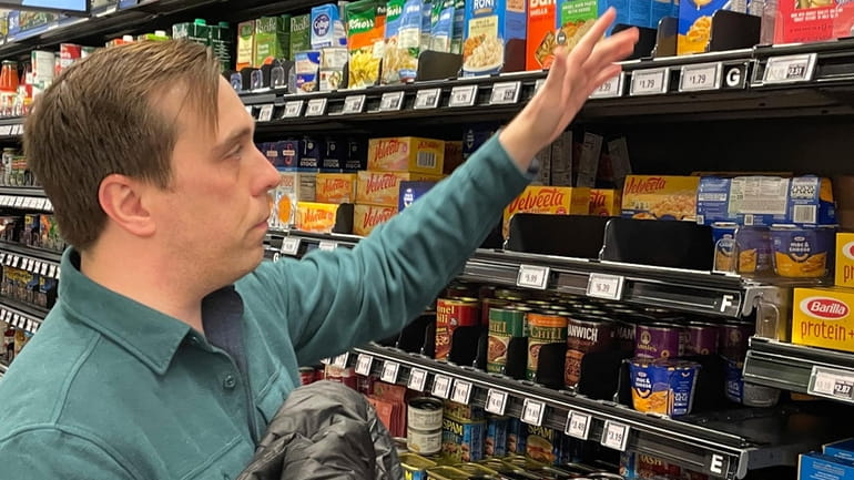 Stuart Dryden reaches for an item at a grocery store...