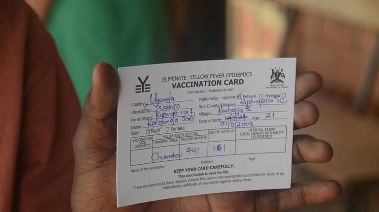 A man holds a vaccination card that proves he has...