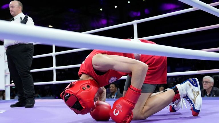 Taiwan's Lin Yu-ting kneels on the mat after a slip...