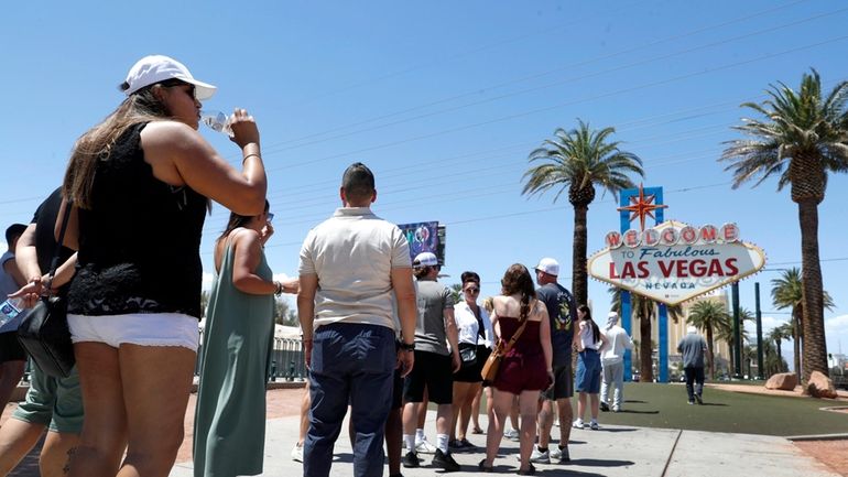 Sofia Ramirez, left, of Mexico drinks water as she waits...