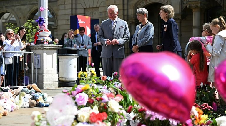 Britain's King Charles III looks at the tributes outside Southport...