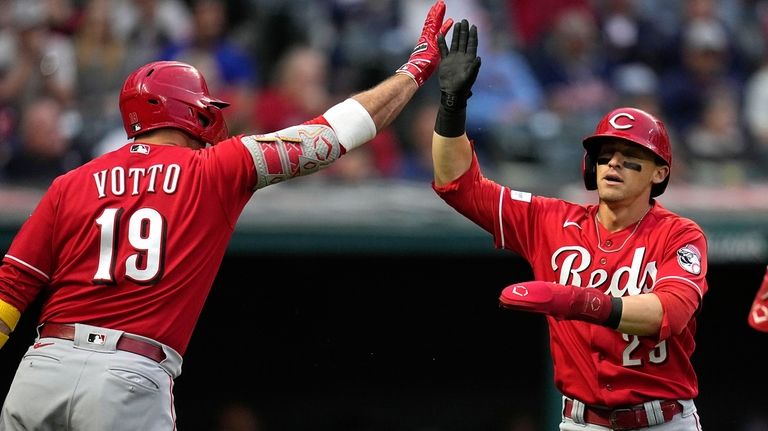 Cincinnati Reds' TJ Friedl, right, is congratulated by Joey Votto...