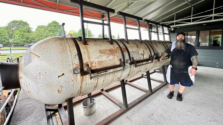 Pitmaster-owner Larry Mondello with his 16-foot-long smoker at Meats Meat...