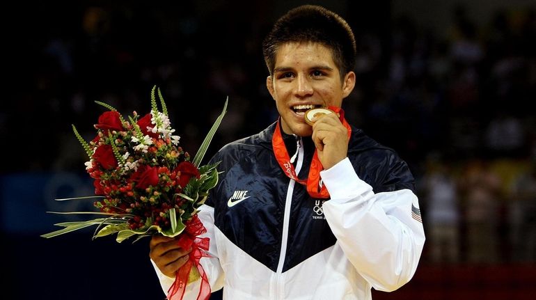 Team USA wrestler Henry Cejudo poses with his Olympic gold...