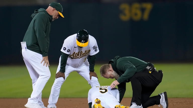 Oakland Athletics' Tony Kemp, bottom, is checked on by manager...