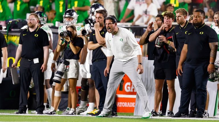 Oregon head coach Dan Lanning shouts to players during the...