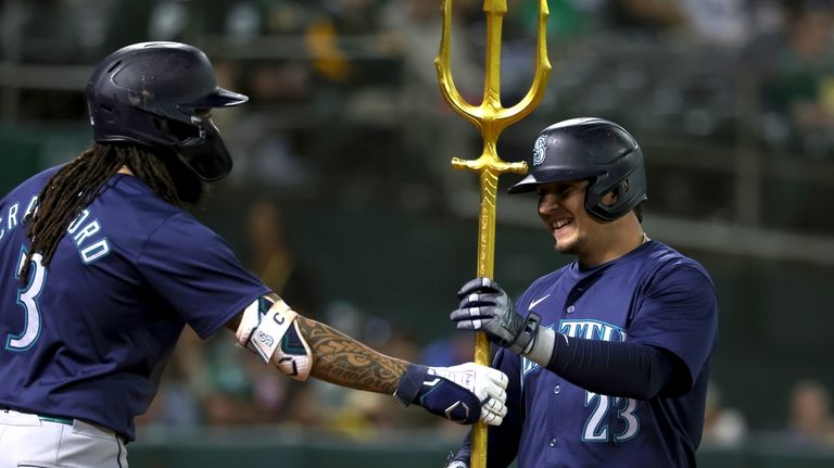 Seattle Mariners' Luis Urías (23) celebrates with J.P. Crawford (3)...