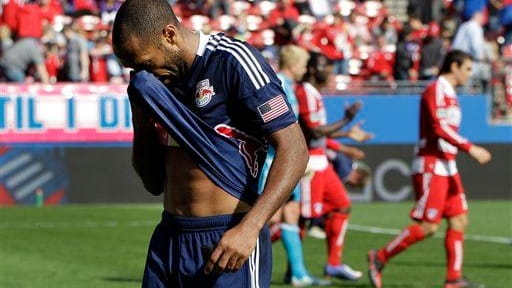 Thierry Henry and FC Dallas players, rear, walk off the...