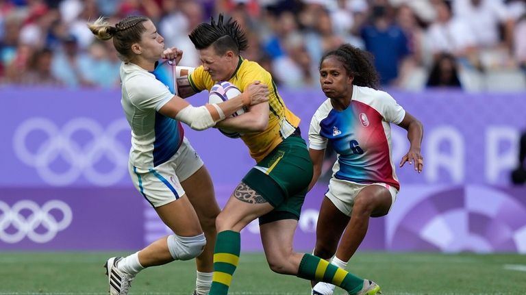 Brazil's Raquel Kochhann, centre is tackled by Joanna Grisez of...