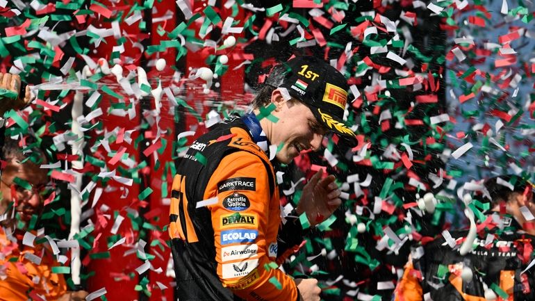 McLaren driver Oscar Piastri of Australia celebrates on the podium...