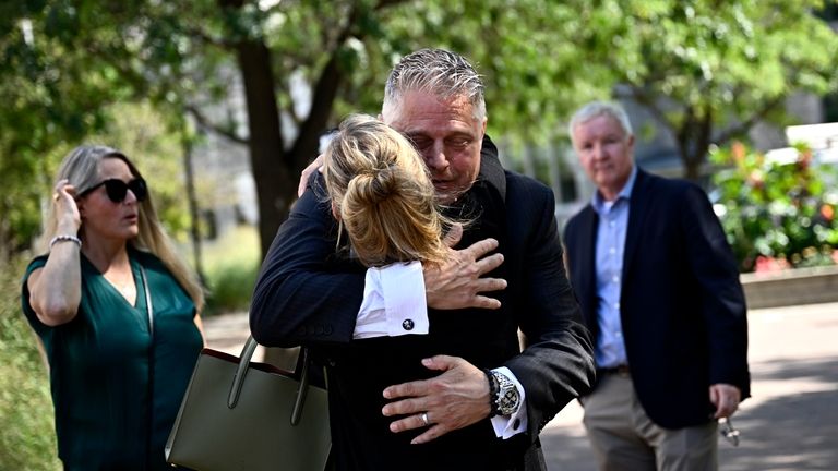 Former vice-admiral Haydn Edmundson embraces a family member after being...