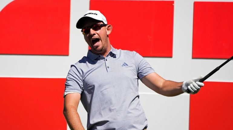 Lucas Herbert, of Australia, yells after hitting the ball left...