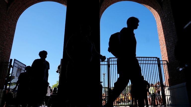 Iowa players arrive at Kinnick Stadium before an NCAA college...