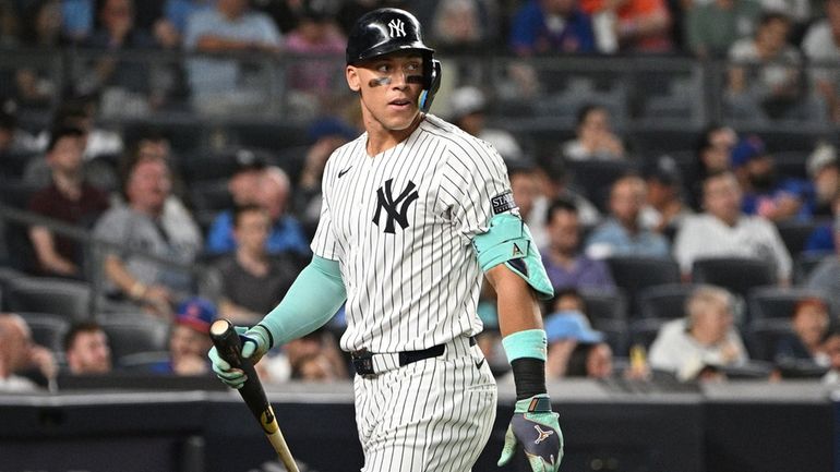 Yankees centerfielder Aaron Judge returns to the dugout after striking...