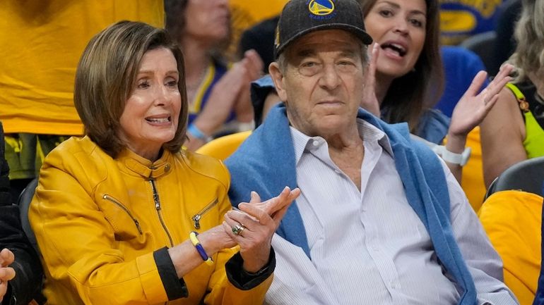 Rep. Nancy Pelosi, D-Calif., left, and her husband, Paul, watch...