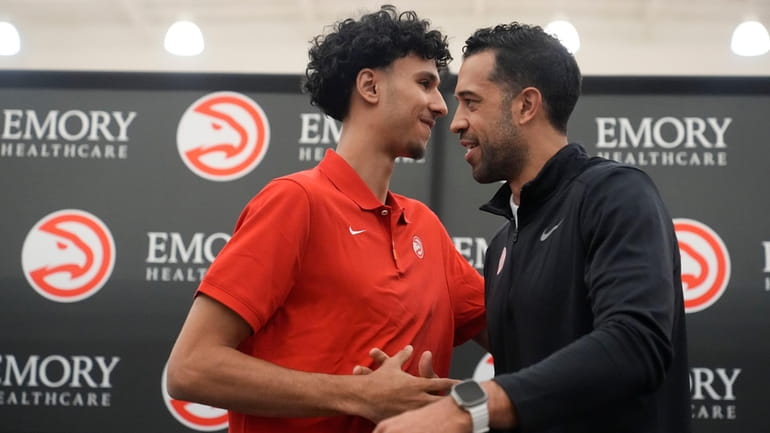 Atlanta Hawks' Zaccharie Risacher, left, and General Manager Landry Fields...
