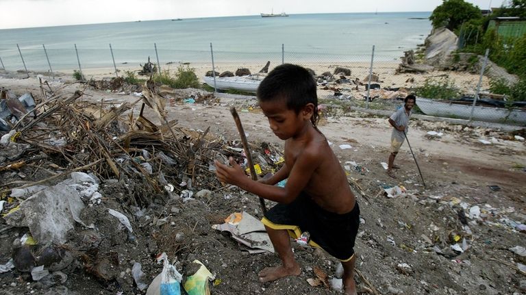 A boy scavenges for useful items at Red Beach dump...