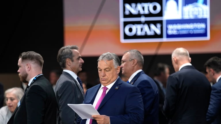 Prime Minister of Hungary Viktor Orban looks over notes during...