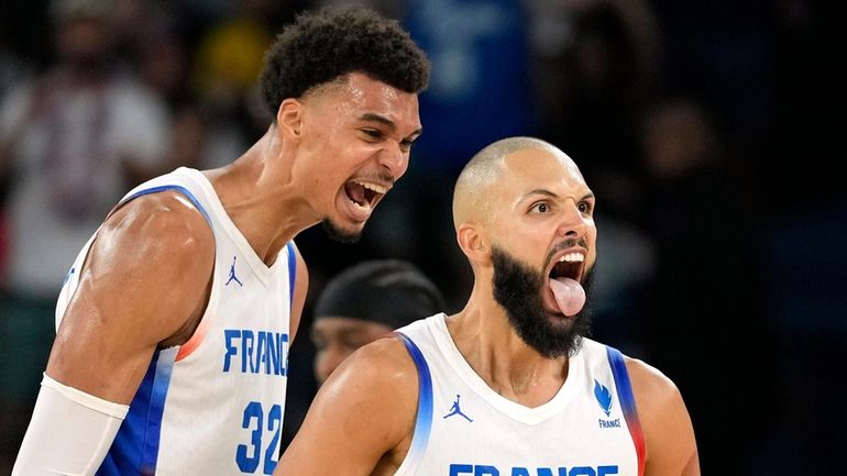 France's Evan Fournier, center, celebrates with France's Victor Wembanyama, right,...