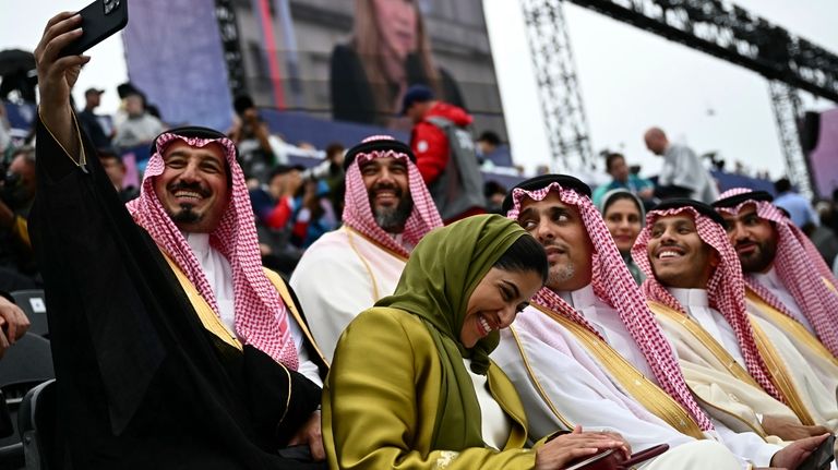 Attendees from Saudi Arabia take selfies ahead the opening ceremony...