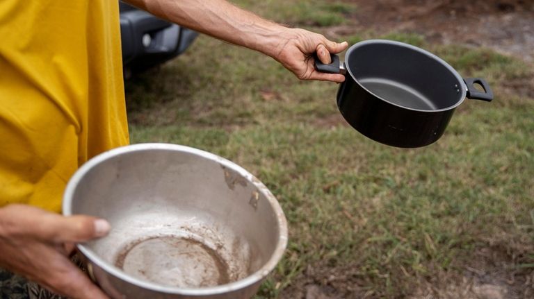 Kyle Ellison shows the pots he used to help put...