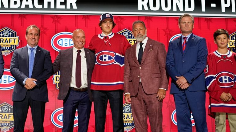 David Reinbacher, center, poses with Montreal Canadiens officials after being...