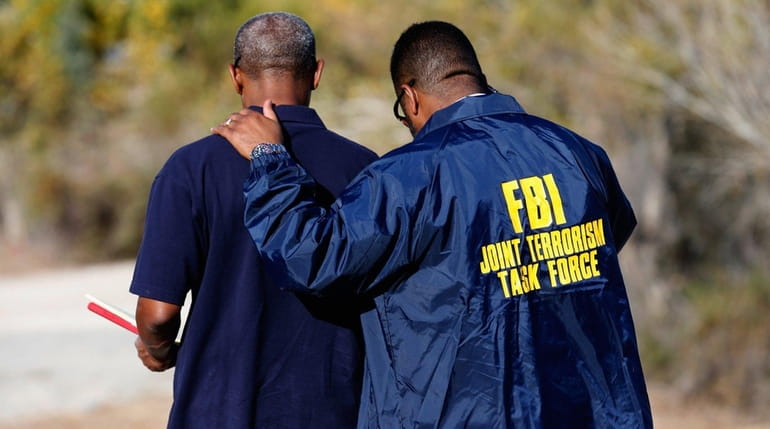 Members of the FBI Joint Terrorism Task Force stand outside...