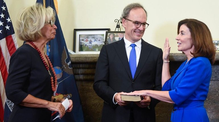 New York Chief Judge Janet DiFiore, left, swears in Kathy...