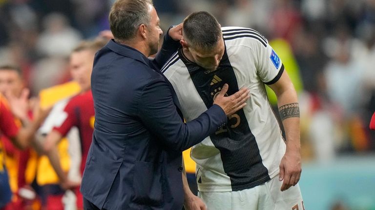 Germany's head coach Hansi Flick, left, talks with Germany's Lukas...