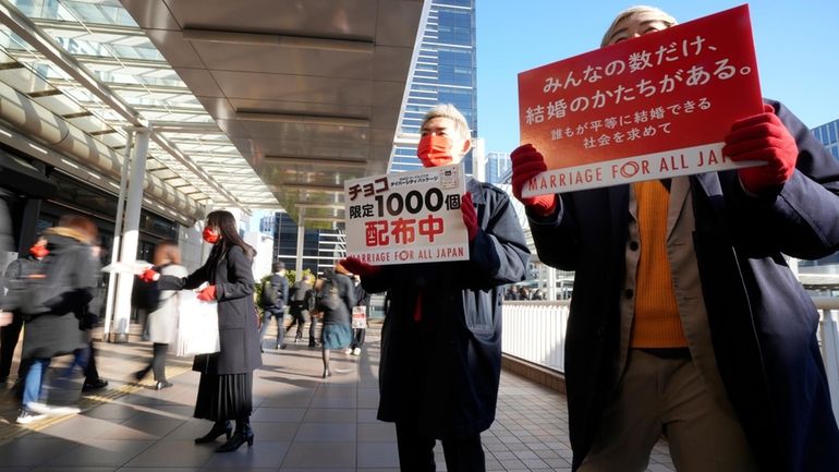 LGBTQ activists distribute chocolates to morning commuters at Shinagawa Station,...