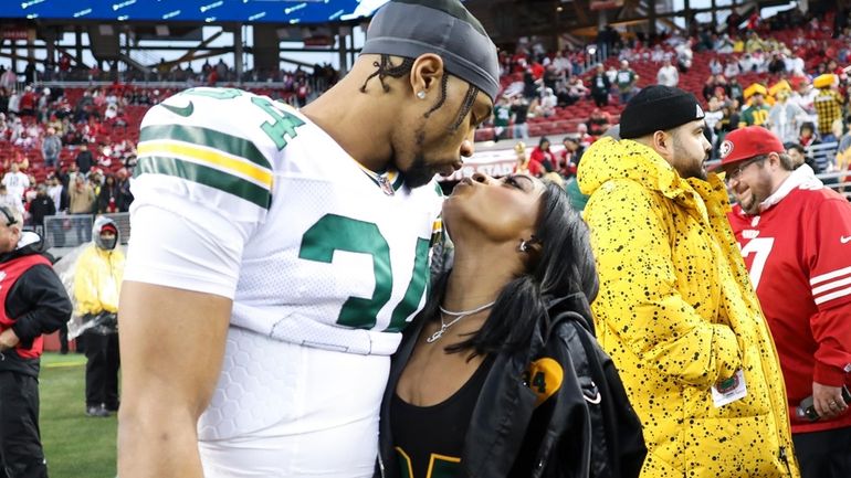 Green Bay Packers safety Jonathan Owens and Simone Biles kiss...