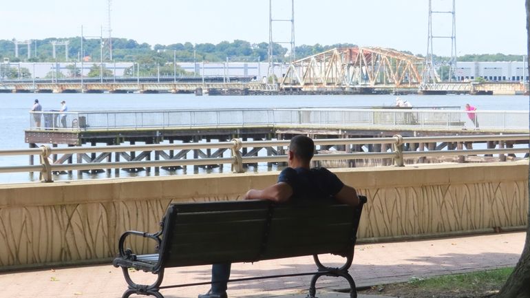 A man relaxes on a bayfront walkway in Perth Amboy,...