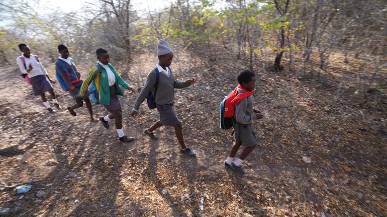 Esther Bote, 14, walks to school with her friends in...