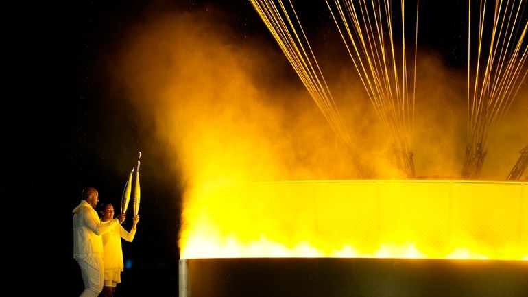 The cauldron is lit by torch bearers Marie-Jose Perec and...