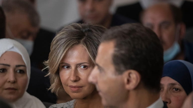 Syria's first lady Asma Assad, second left, listens to her...