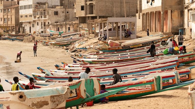 Children play on fishing boats known as "pirogues" in Dakar,...