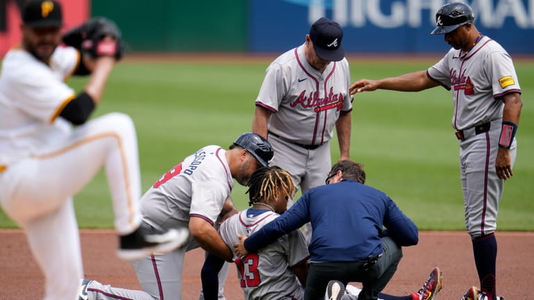 Atlanta Braves' Ronald Acuña Jr. is tended to after being...