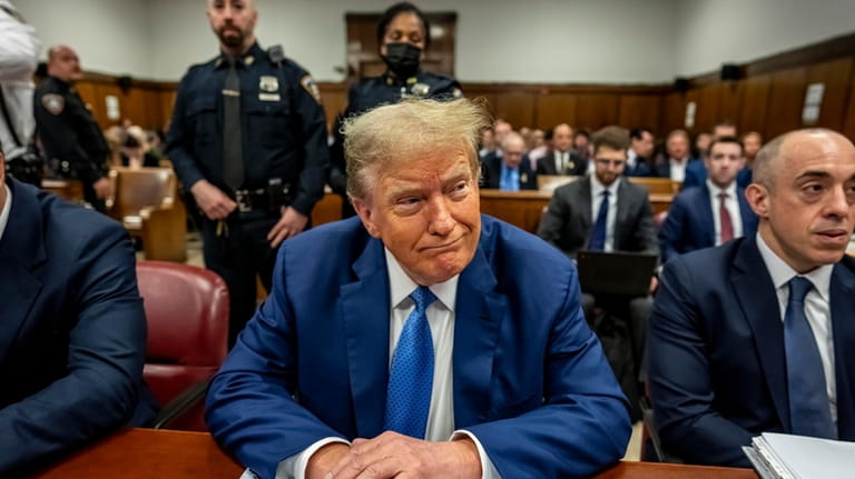 Former President Donald Trump sits in Manhattan Criminal Court in...