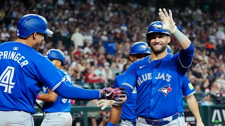 Toronto Blue Jays' Kevin Kiermaier, right, waves to the crowd...