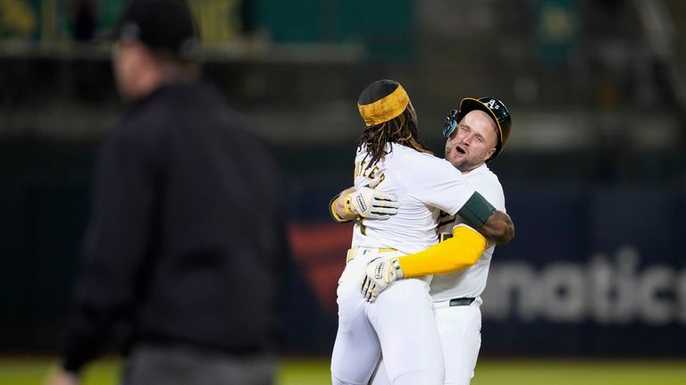 Oakland Athletics' Seth Brown, right, is hugged by Lawrence Butler...