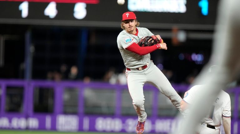 Philadelphia Phillies second baseman Bryson Stott throws to first where...