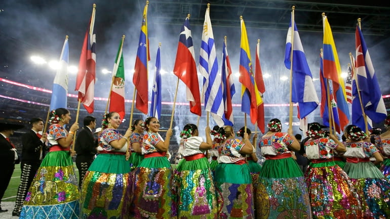 Dancers with the Ballet Folklorico De San Antonio carry flags...