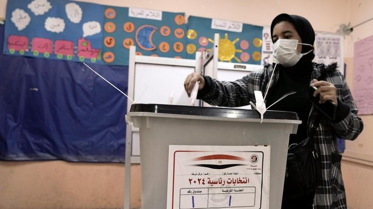 A woman casts her vote for the presidential elections at...