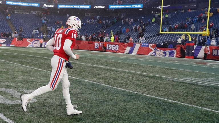 New England Patriots quarterback Mac Jones (10) heads to the...