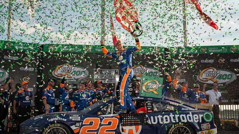 Joey Logano, center, celebrates after winning a NASCAR Cup Series...