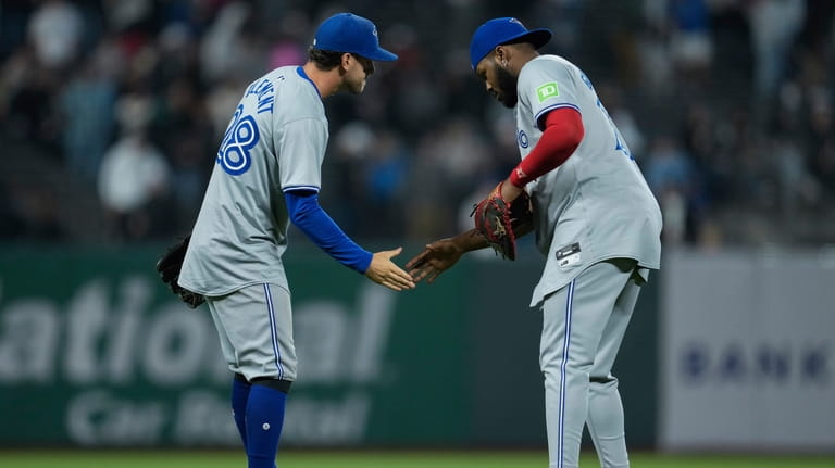 Toronto Blue Jays third baseman Ernie Clement, left, and first...