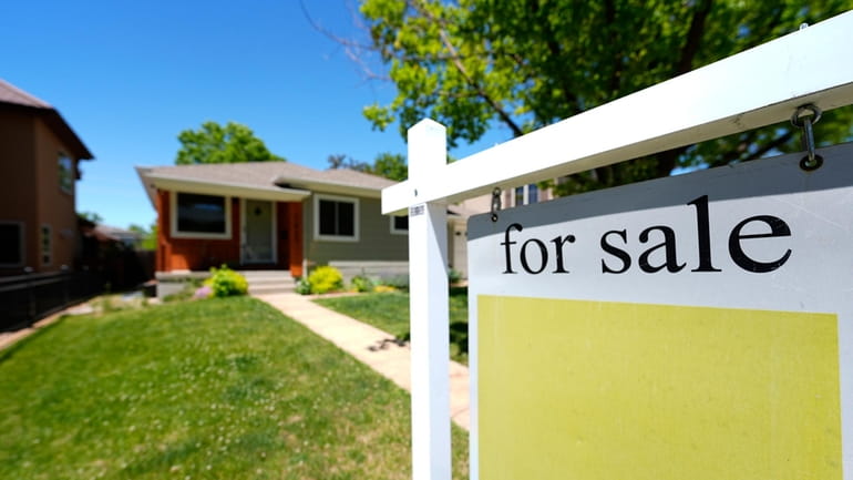 A for sale sign stands outside a single-family residence on...