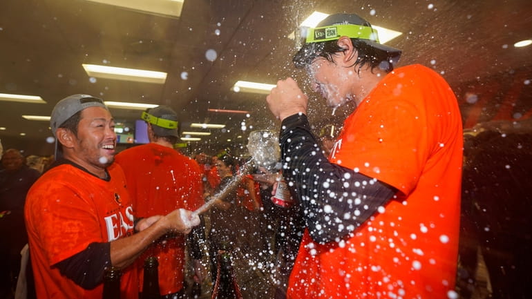 Baltimore Orioles relief pitcher Shintaro Fujinami, right, is doused by...